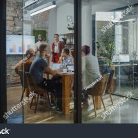 stock-photo-stylish-office-conference-room-meeting-female-and-male-ceo-deliver-speech-to-a-diverse-group-of-1919479589